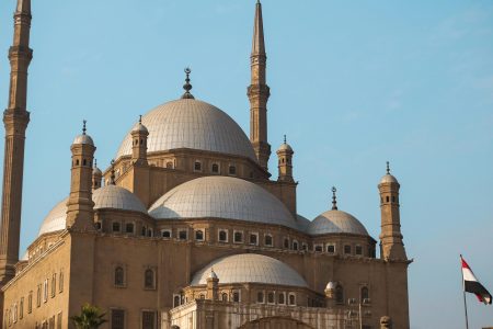Explore the architectural beauty of the historic mosque in Cairo, featuring majestic domes and minarets.