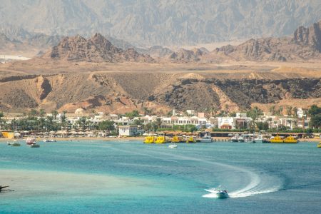 A stunning seaside town with turquoise waters and rugged mountains.