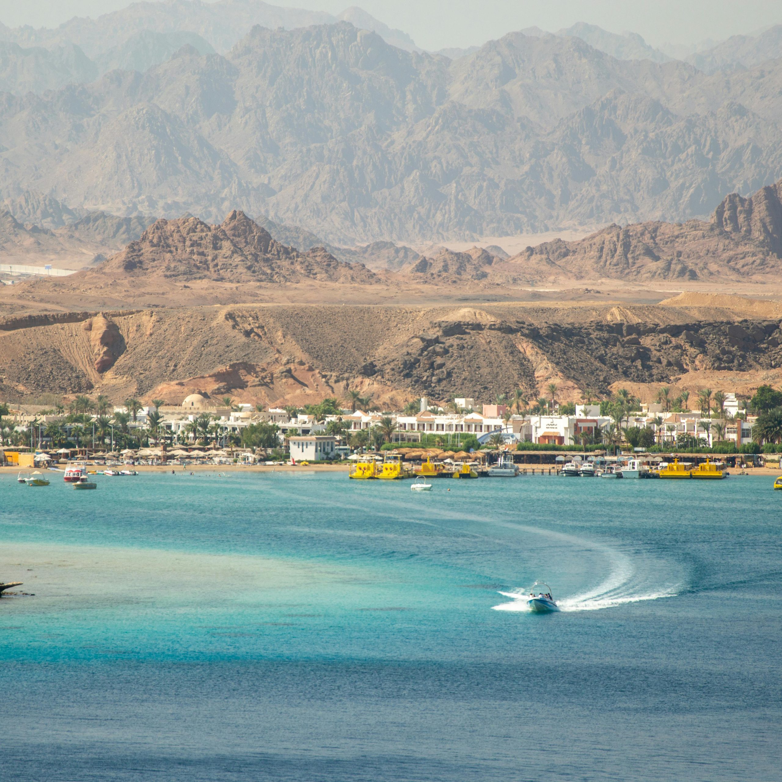 A stunning seaside town with turquoise waters and rugged mountains.