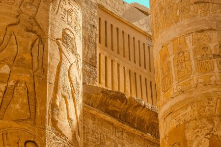 Explore the ancient Egyptian hieroglyphs on the grand columns of Karnak Temple on a sunny day.