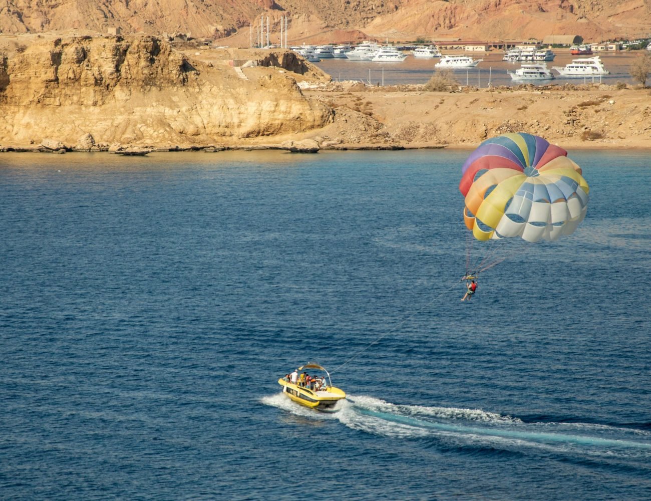 Enjoy a thrilling parasailing experience with stunning coastal views and a colorful parachute.